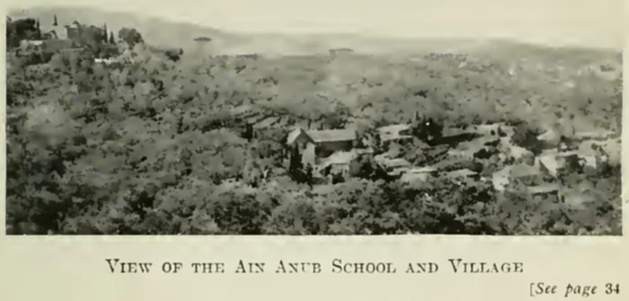 1917 photograph of Ain Anub village among wooded hills, with the school buildings in the middle distance