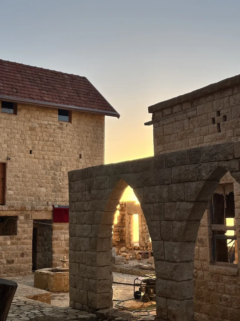 The fountain courtyard of Qasr Noun at dusk, restored stone arches
